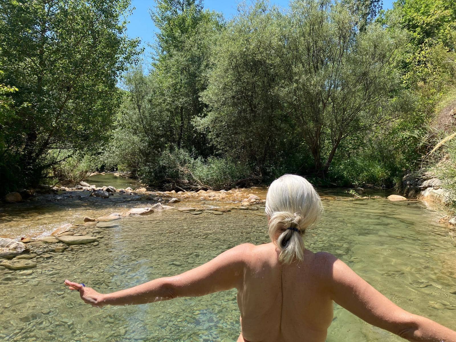 Laurence dans la riviere, les bras ouverts, pendant le sejour en Drome