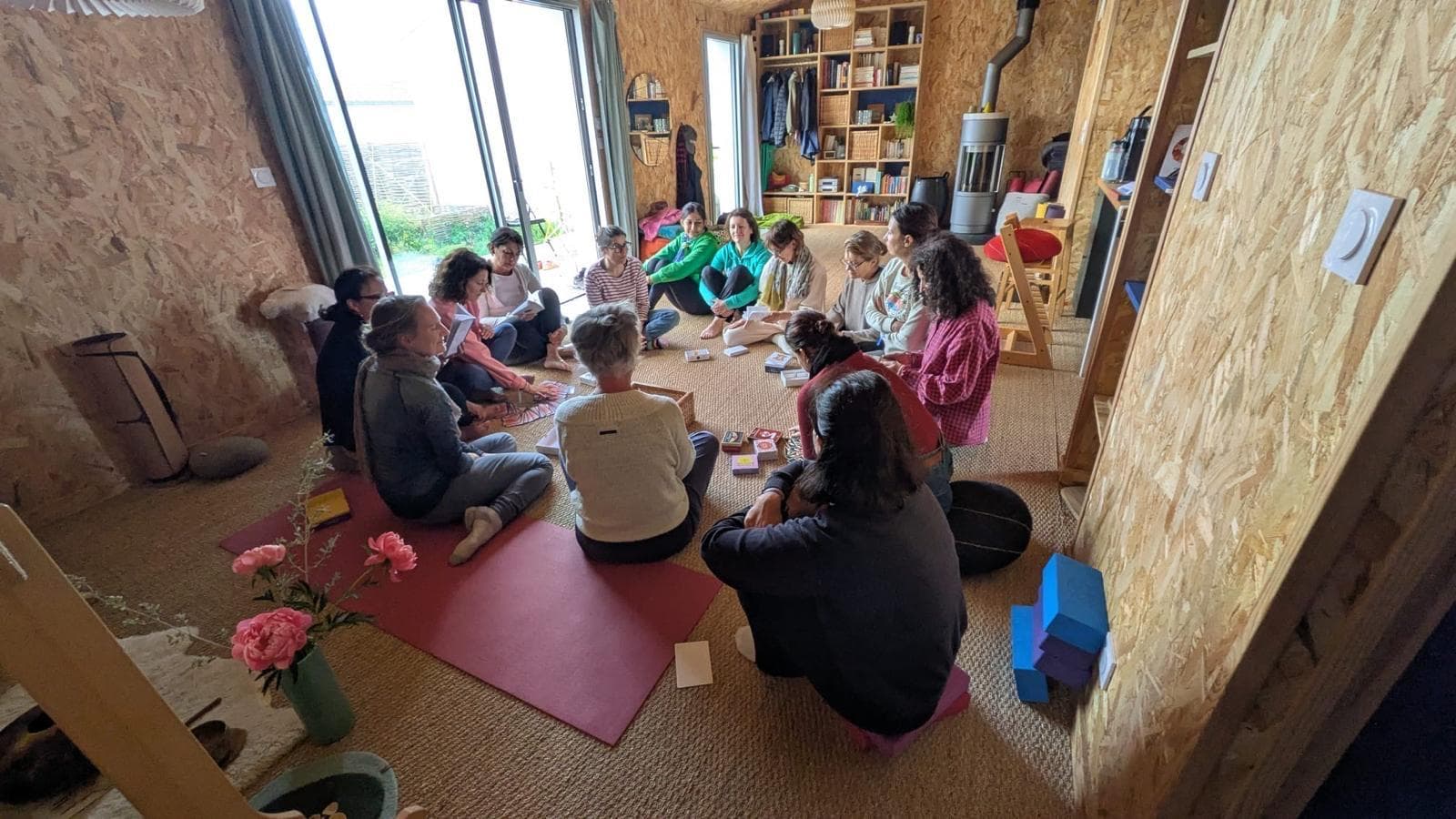 Le groupe en cercle dans la maison en bois, autour des instruments
