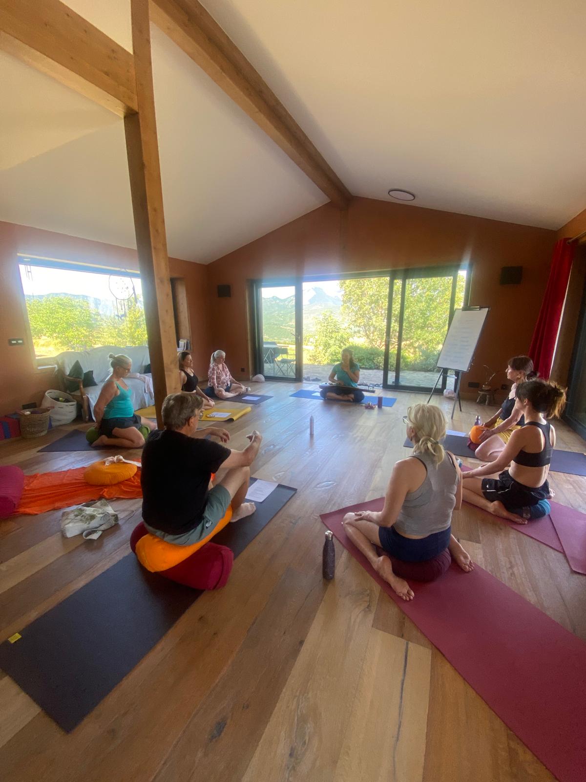 Les participants assis en cercle autour de Laurence dans la salle de yoga