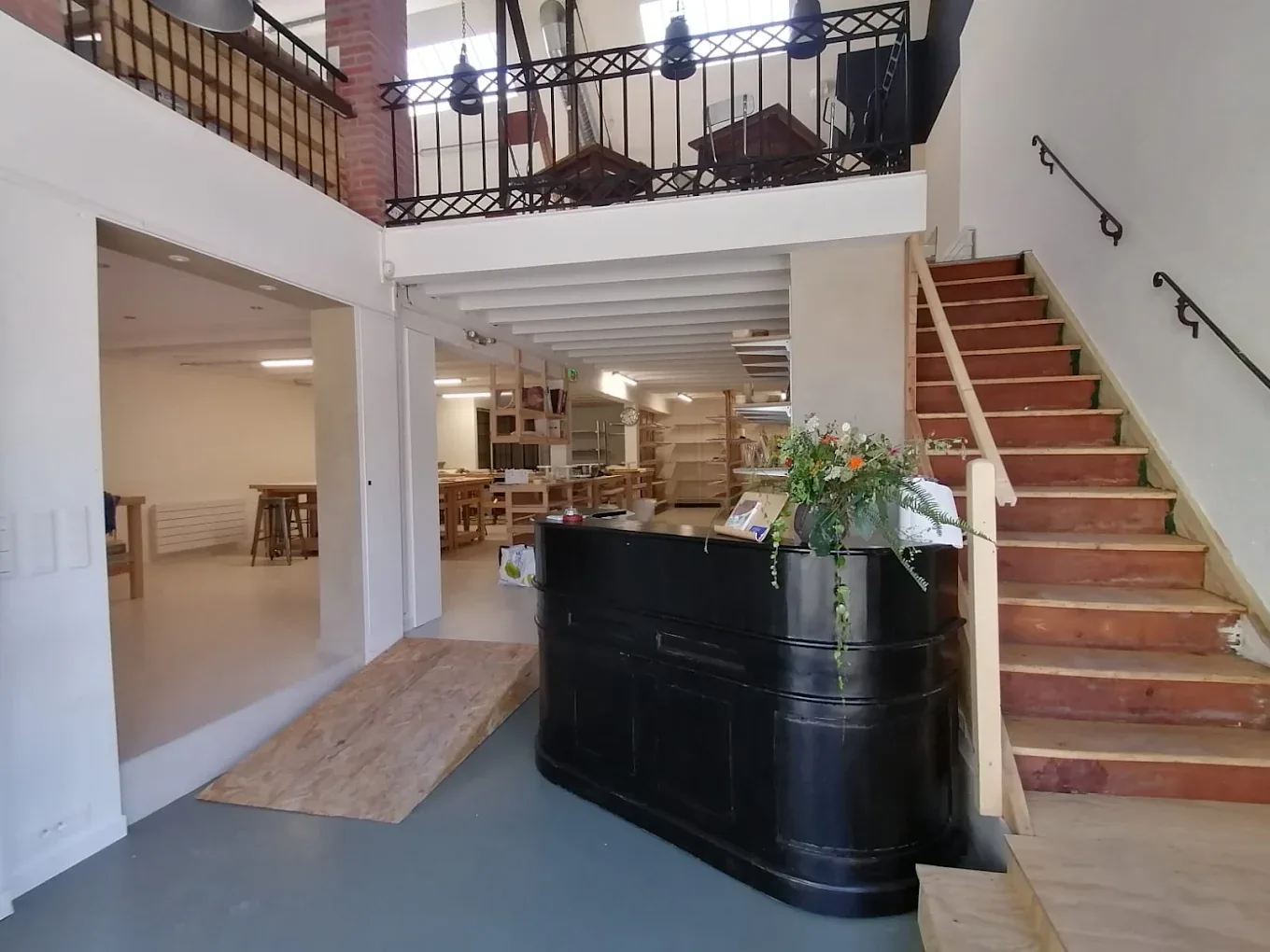 L'intérieur de l'atelier Le Quatre, comptoir noir et escalier de bois