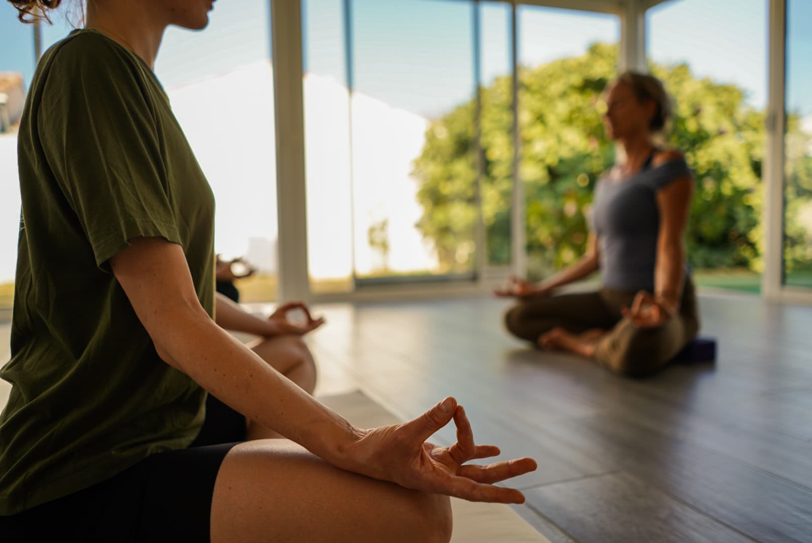 Deux élèves assises en tailleur, mains en mudra, pendant la relaxation