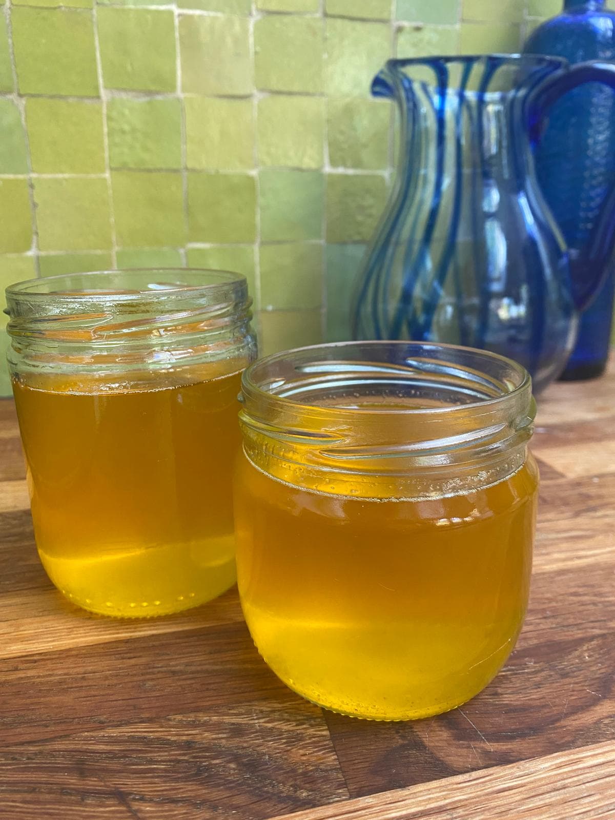 Le ghee filtré, doré et translucide, dans deux bocaux en verre ouverts