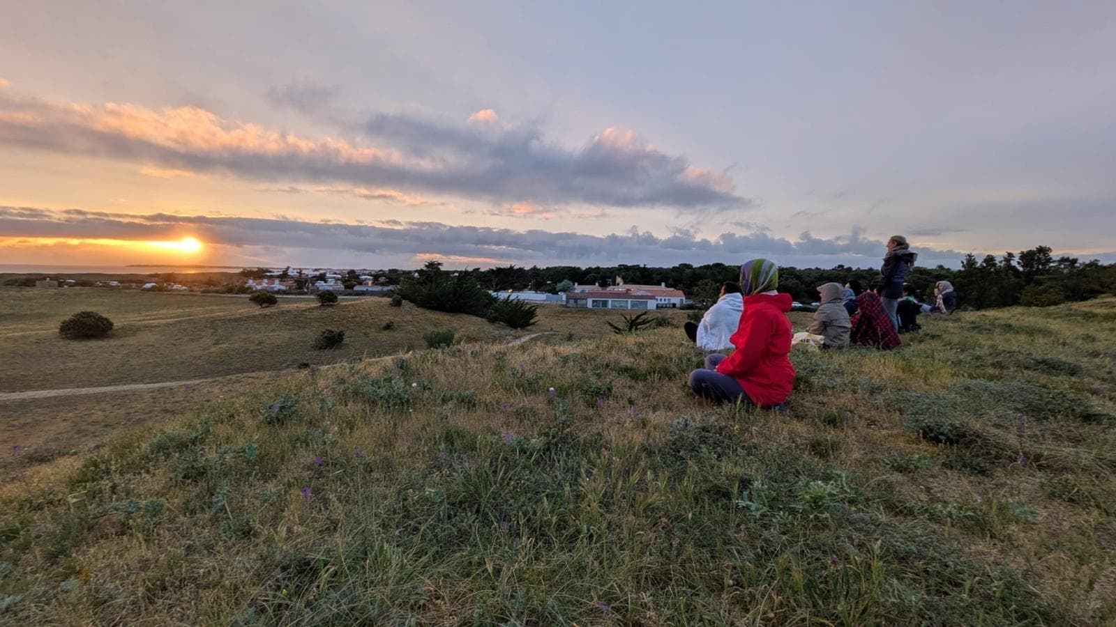 Le groupe assis dans les dunes de Noirmoutier face au soleil couchant